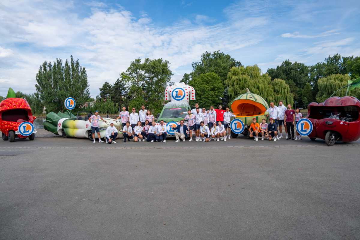 Équipe E.Leclerc en maillot à pois posant devant les chars emblématiques de la caravane sur le Tour de France.