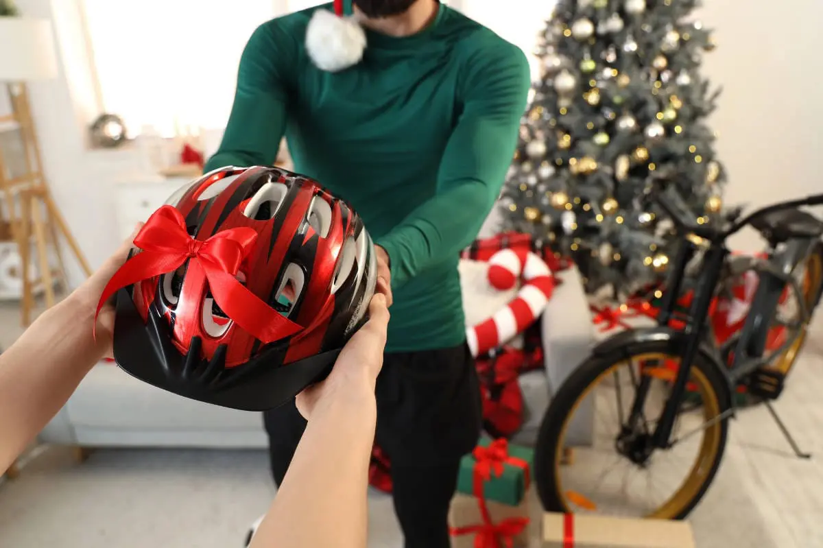 Jeune homme sportif recevant un casque de vélo comme cadeau
