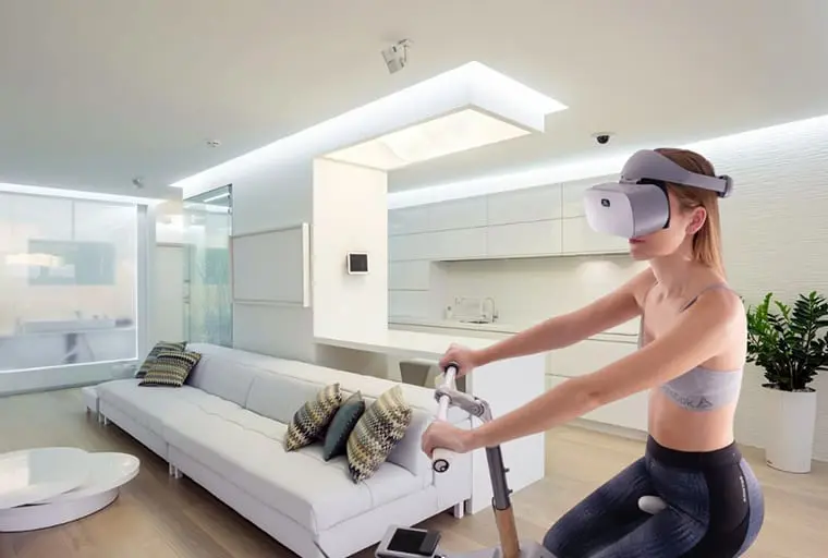 Femme sur un vélo d'appartement portant un casque de réalité virtuelle